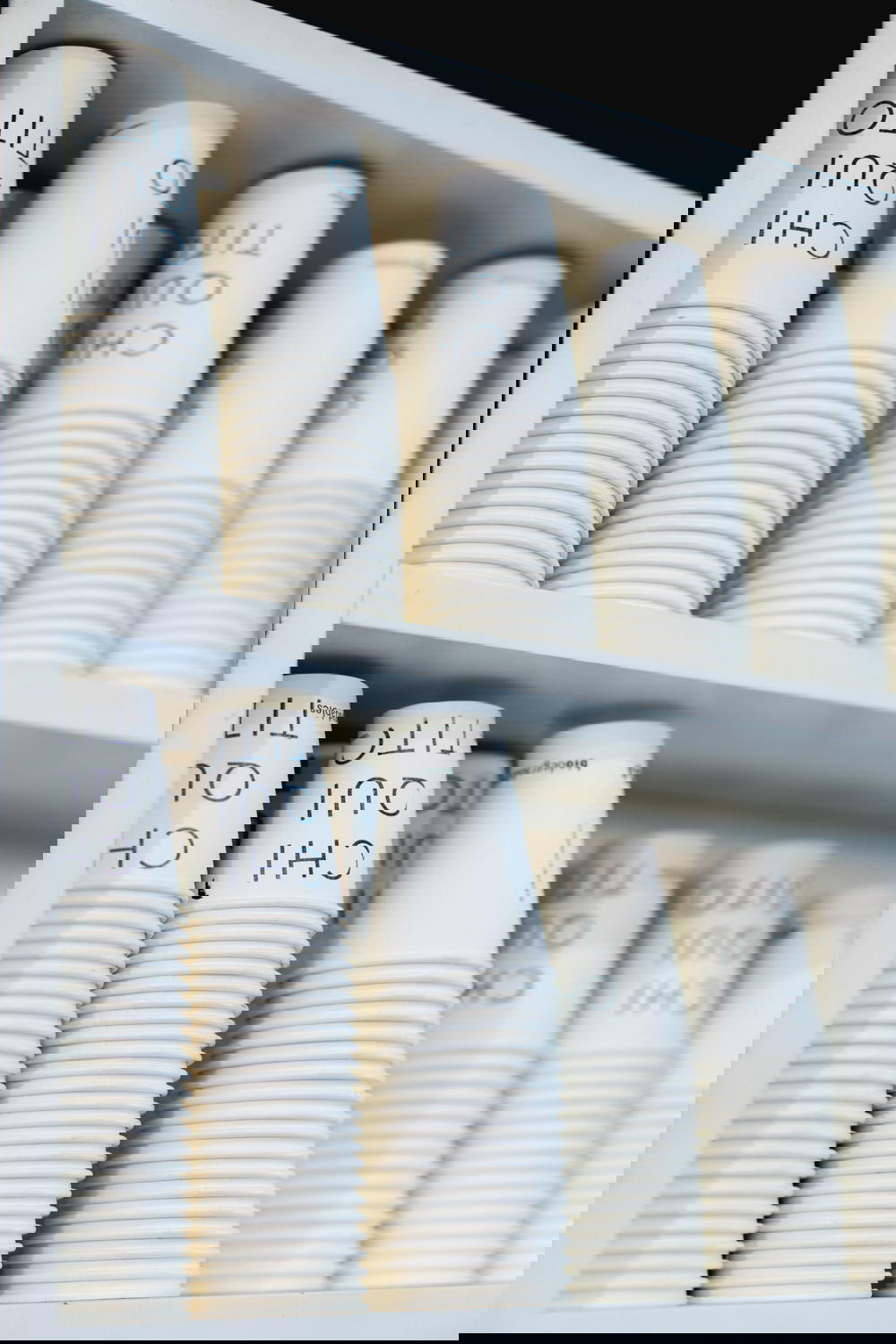 Stacks of paper coffee cups in a coffee shop shelf