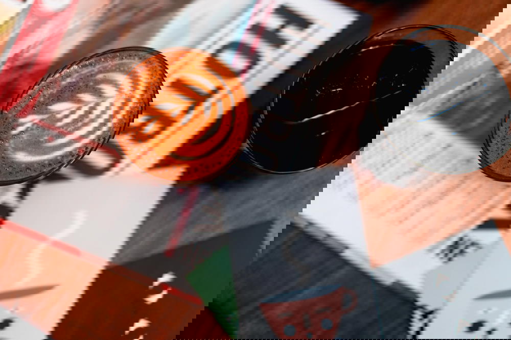 Leaf latte art in a glass cup on top of a newspaper on a wooden table at a cafe in Mexico City