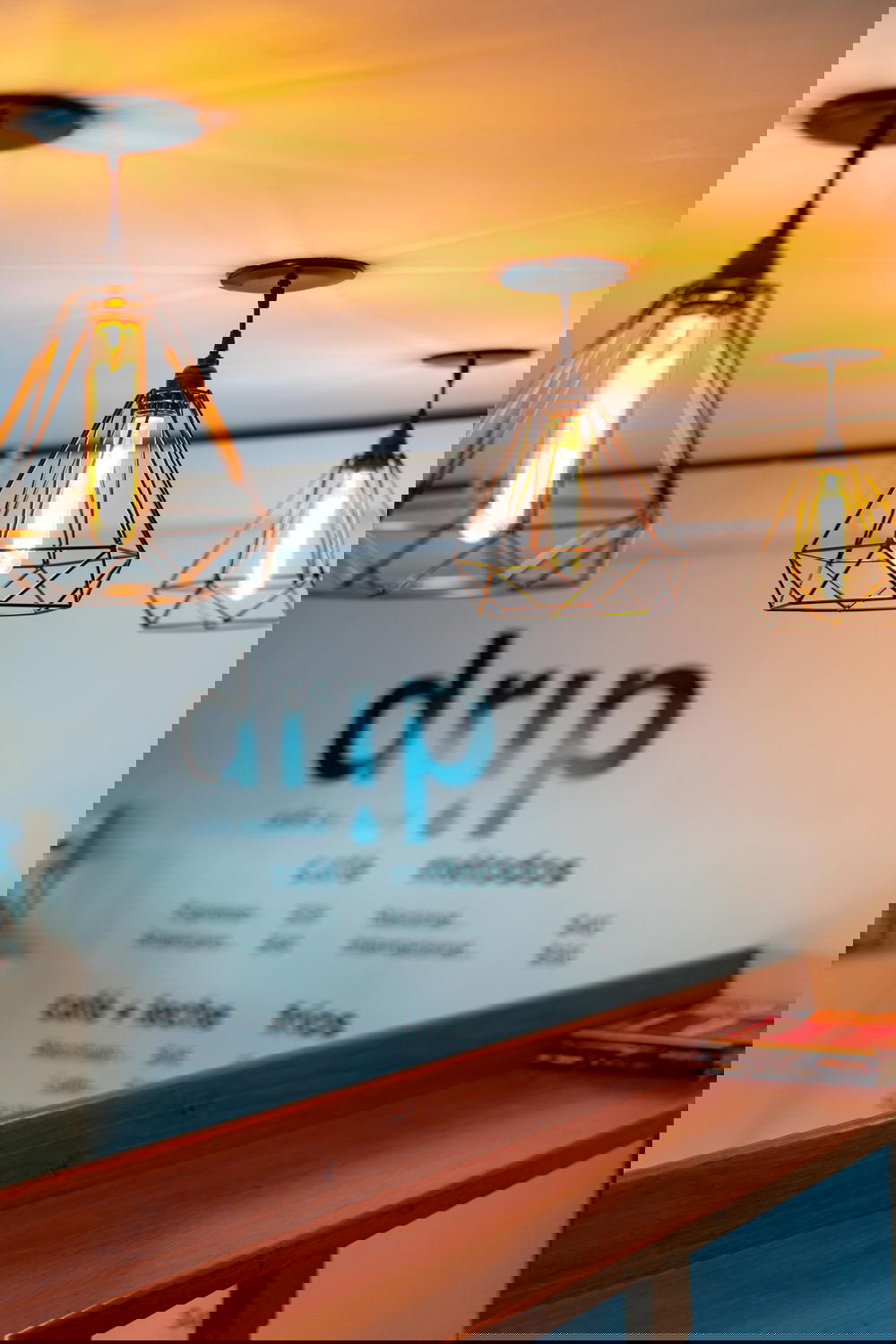 A bar in Mexico with lights hanging over a counter and a sign that says drip.