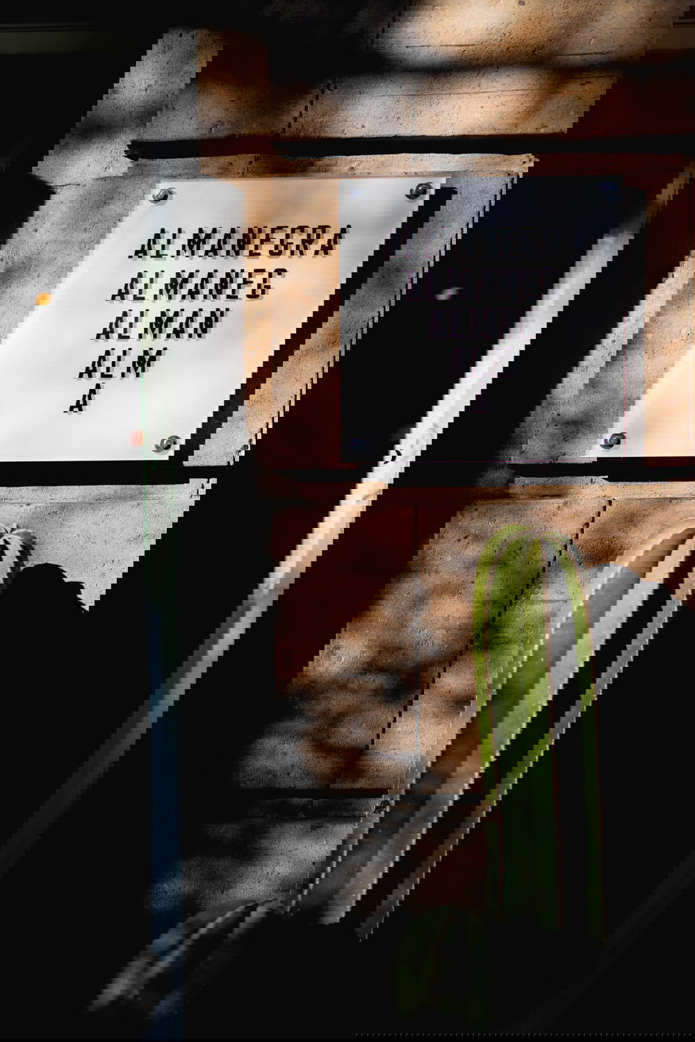 Almanegra sign with black letters on a white piece of glass outside the cafe in Mexico City