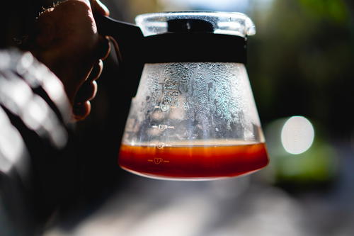 A person holding a glass of Mexican coffee.