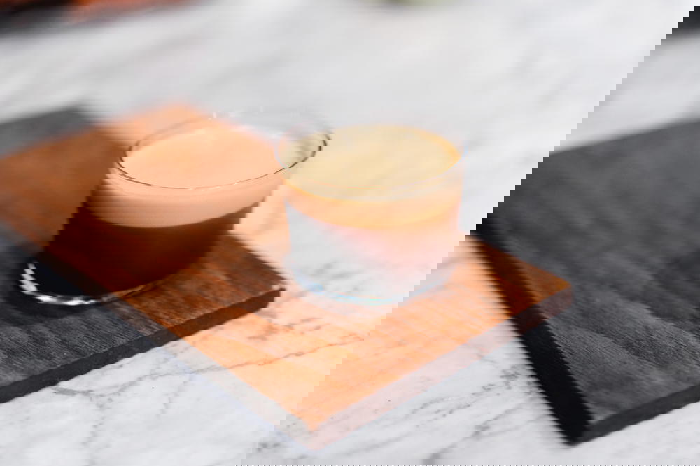 A glass of espresso on a Mexican wooden cutting board.