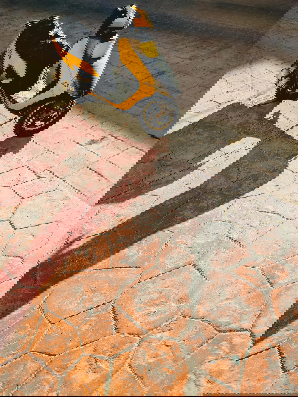 A yellow scooter parked on a sidewalk in Mexico.