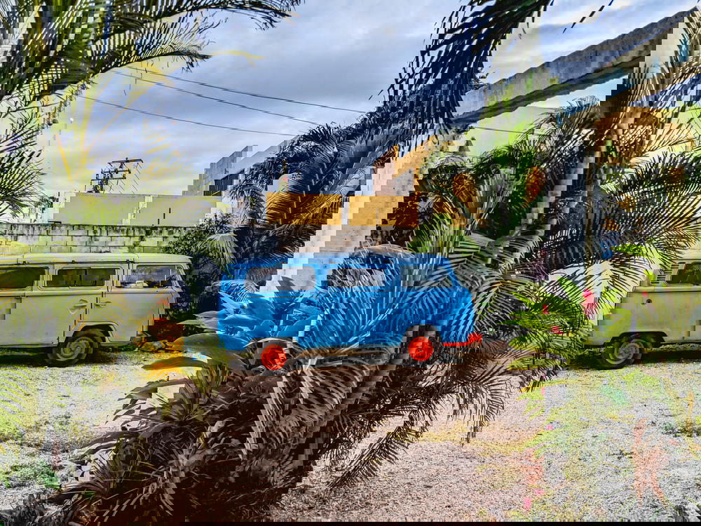 A blue VW bus parked in front of a house in Mexico.