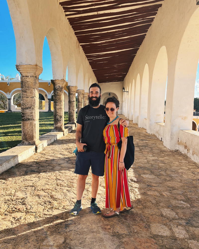 A couple posing in front of an archway in Izamal, Mexico.