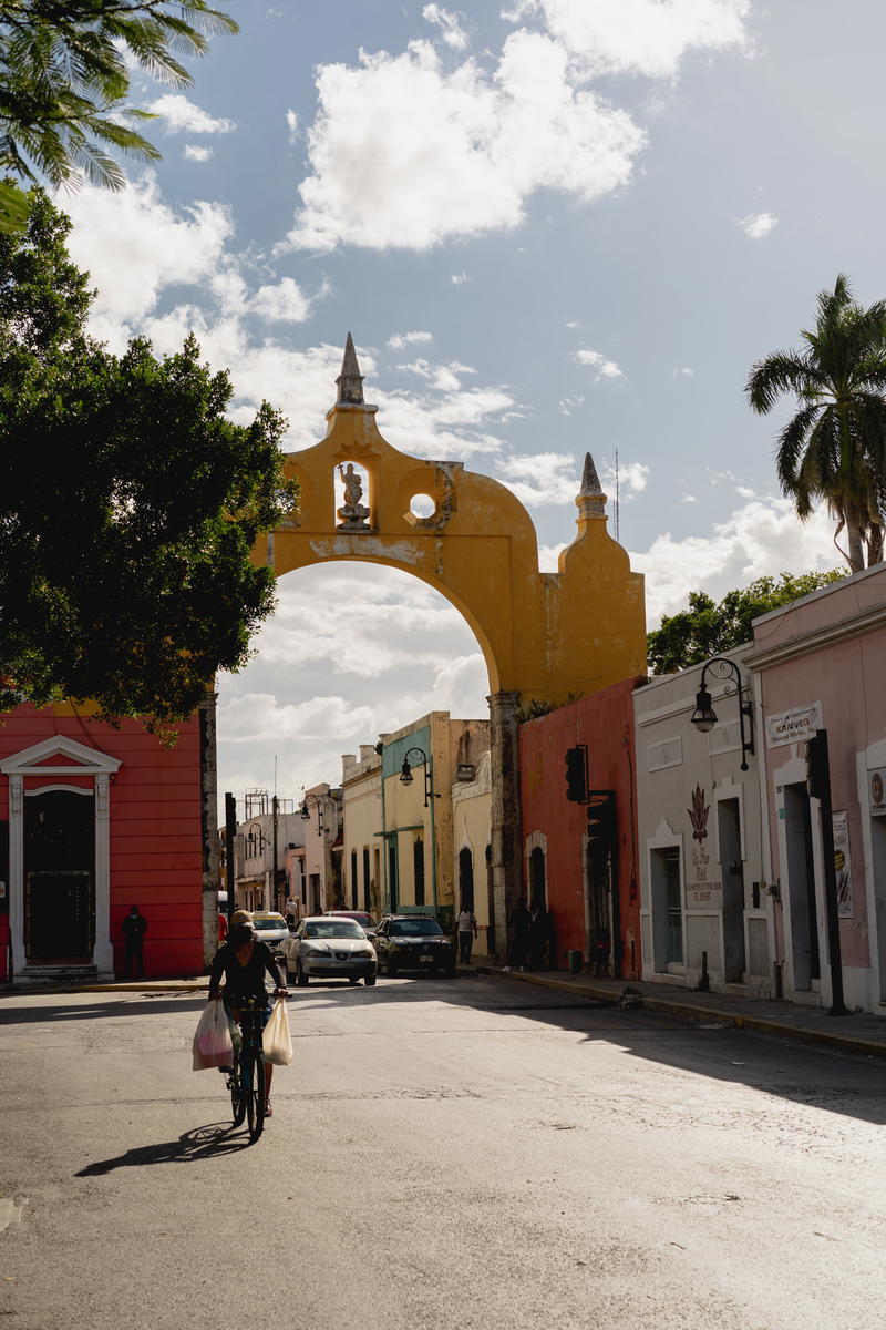 A person riding a bike down a street in Merida, Mexico.