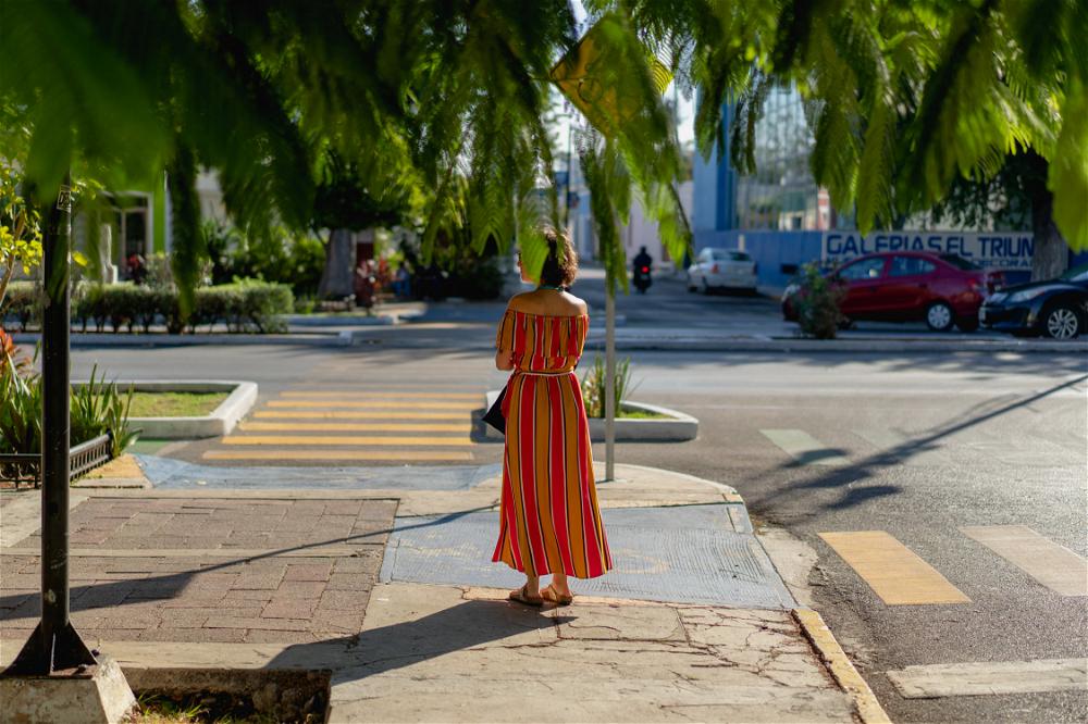 A woman walking down the street in Merida, Mexico.