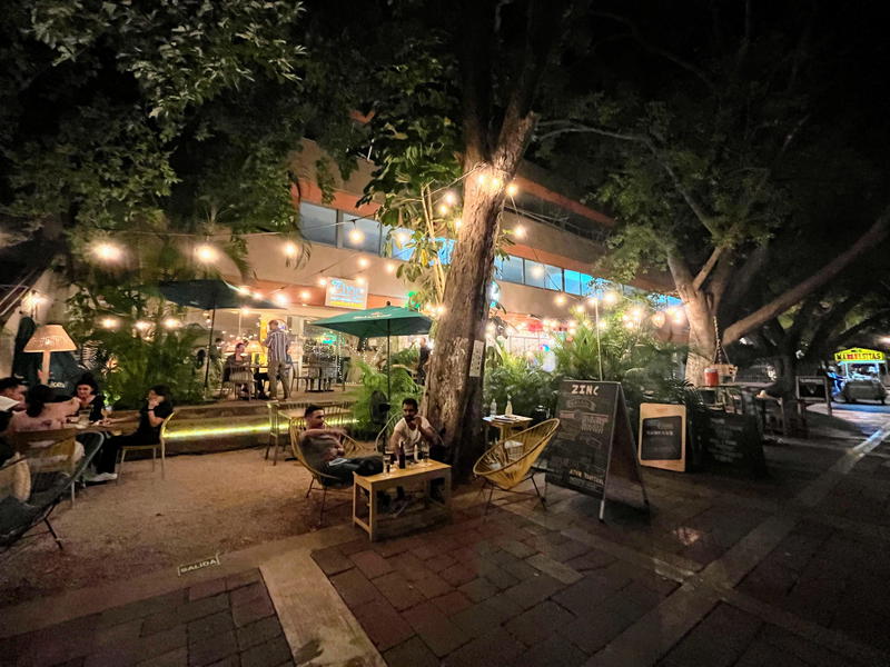 A night-time restaurant with tables and chairs outside in Merida, Mexico.