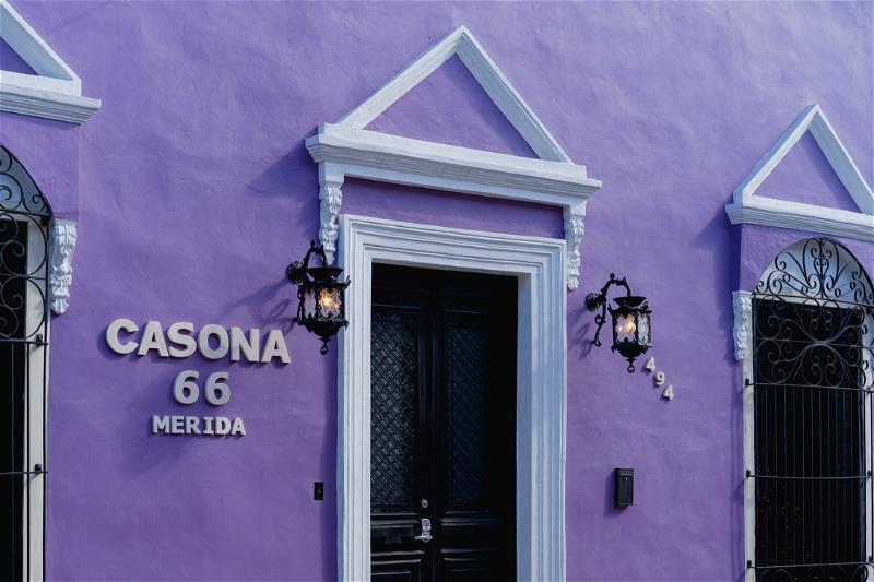 A purple building in Merida, Mexico with a door that says cassana 66.