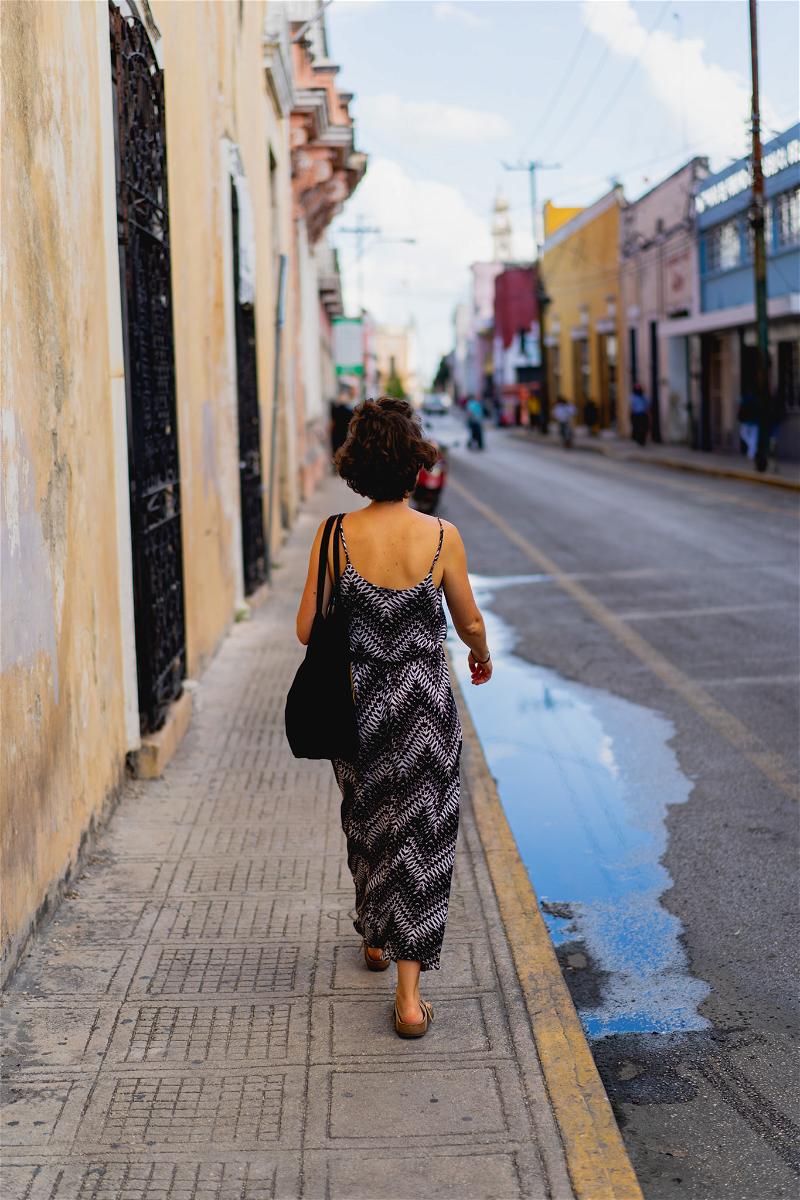 A woman walking down a street in Merida.
