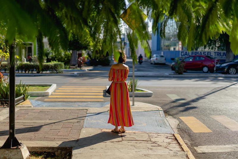 A woman strolling in Merida, Mexico wearing a striped dress.