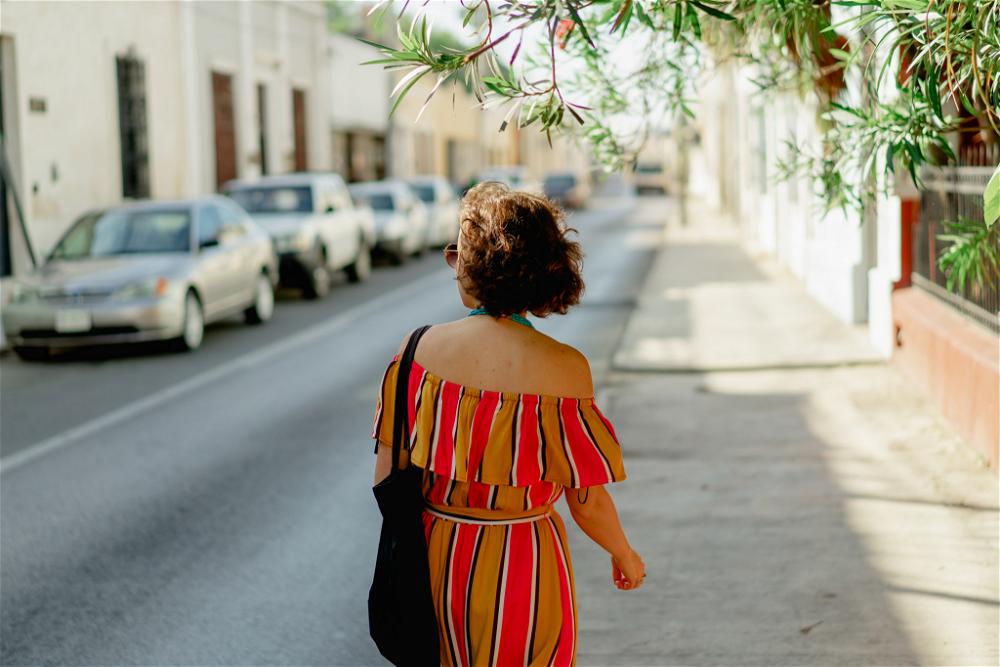 A woman walking down a street in Merida, Mexico.