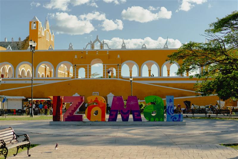 A colorful statue of the word izmal in front of a building in Merida, Mexico.