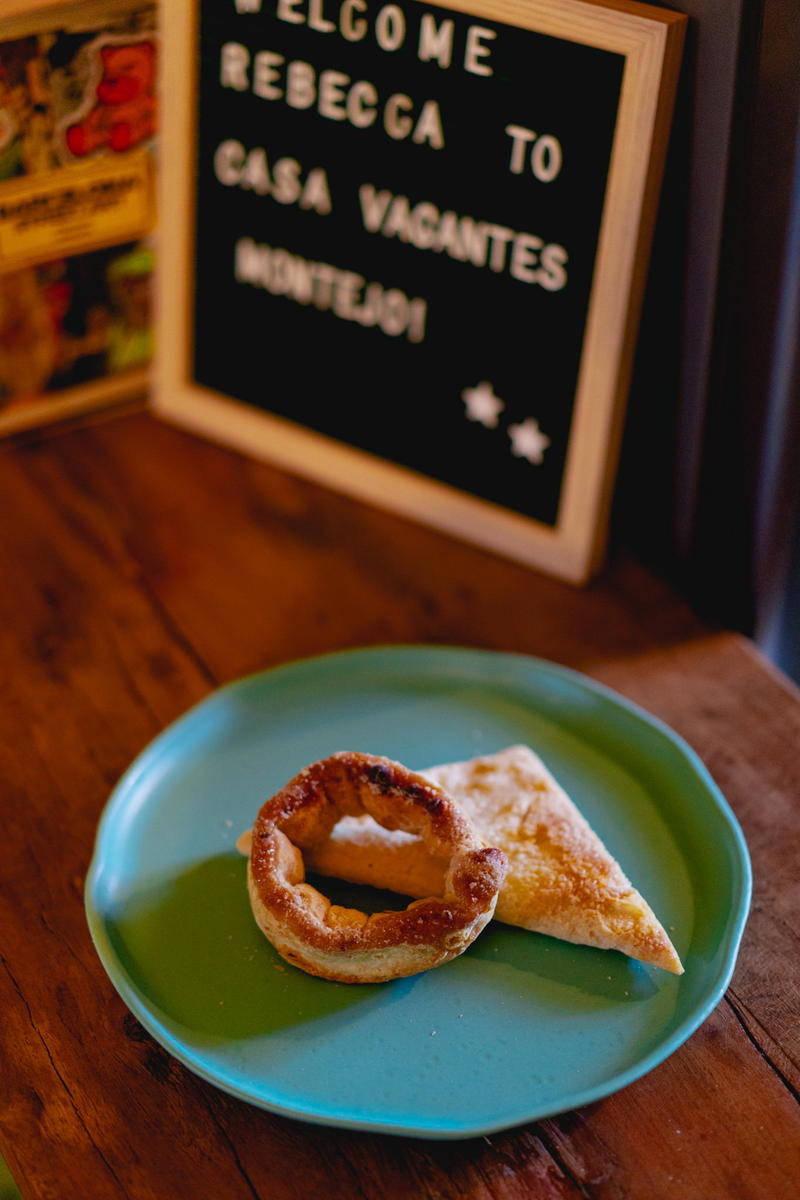 A plate with a donut on it sits on a wooden table in Mexico.