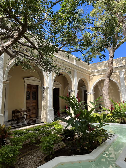 A courtyard with a fountain and trees in Merida, Mexico.