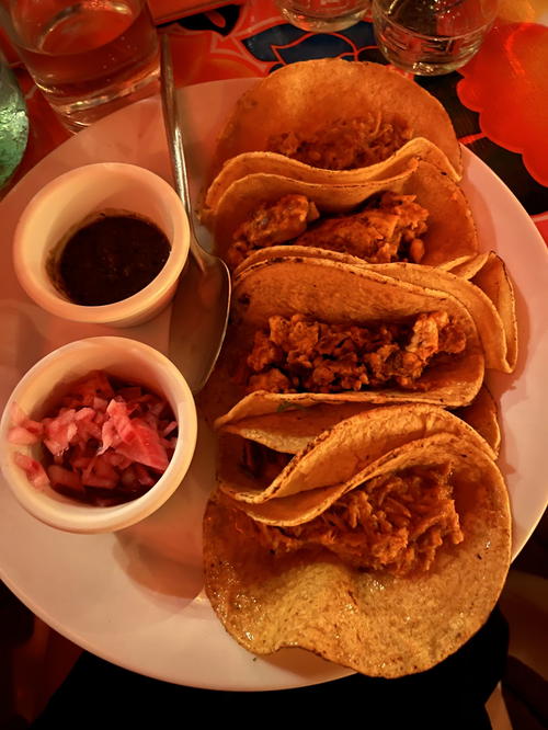 A plate of Merida-style tacos with sauce on it.