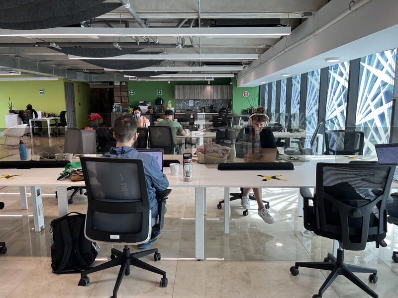 A group of people sitting at desks in an open office in Merida, Mexico.