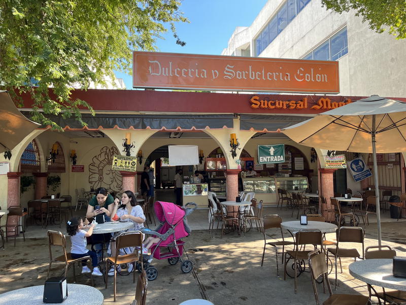 A group of people sitting at tables outside of a restaurant in Merida, Mexico.