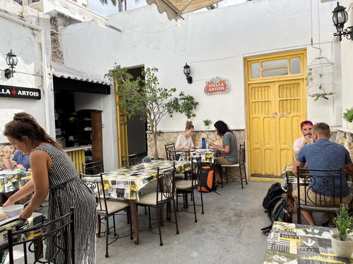 A group of people sitting at tables in a courtyard in Merida, Mexico.