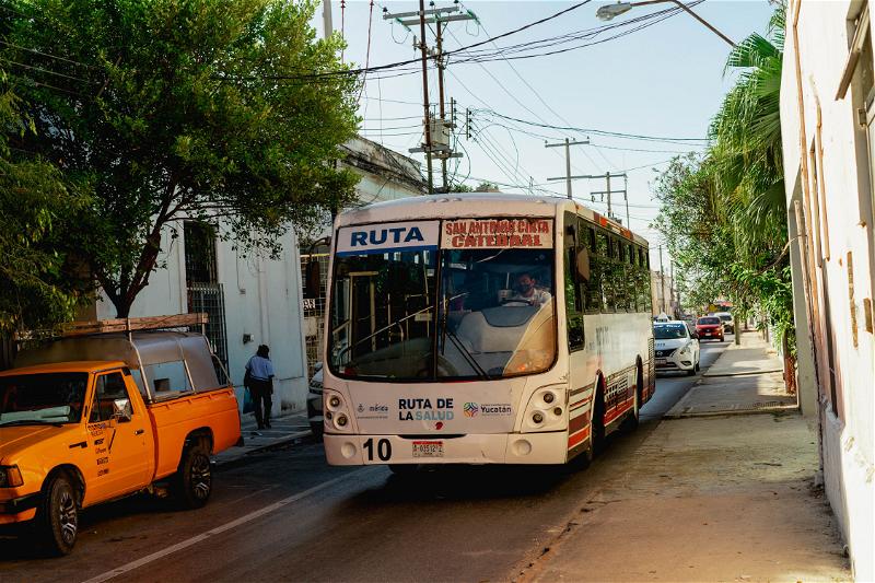 A Merida bus driving down a street in Mexico.