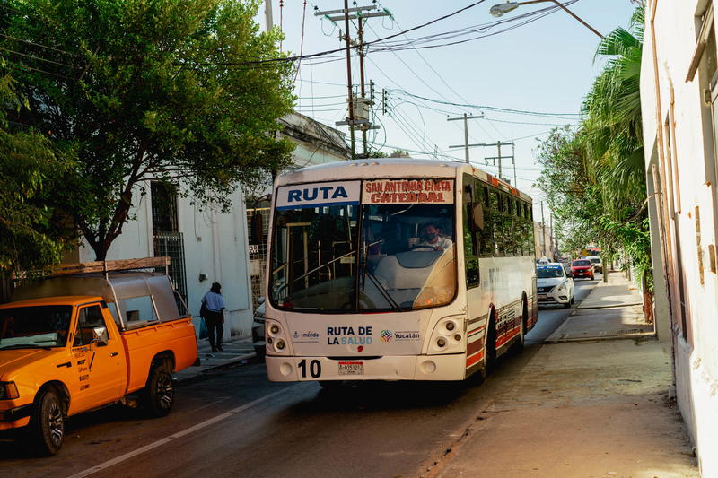 A Merida bus driving down a street in Mexico.