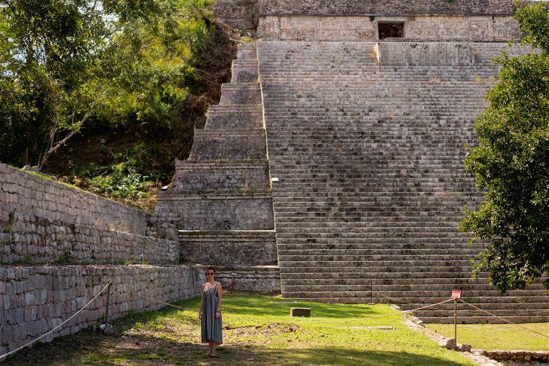 A woman standing in front of an ancient pyramid in Merida, Mexico.