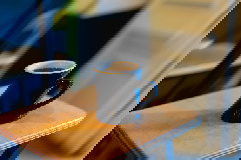A cup of Almenegra coffee sits on a wooden table in Mexico City.