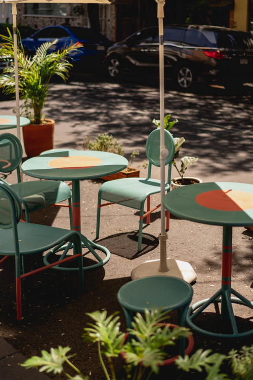 A table and chairs on a sidewalk in Mexico City.