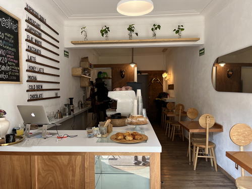 A coffee shop in Mexico City featuring wooden tables and shelves.