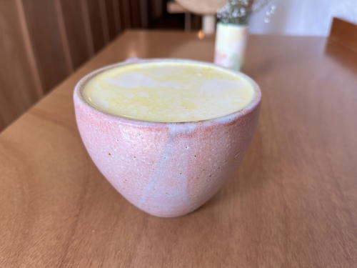 A mug with a cup of coffee sitting on top of a wooden table in Mexico City.
