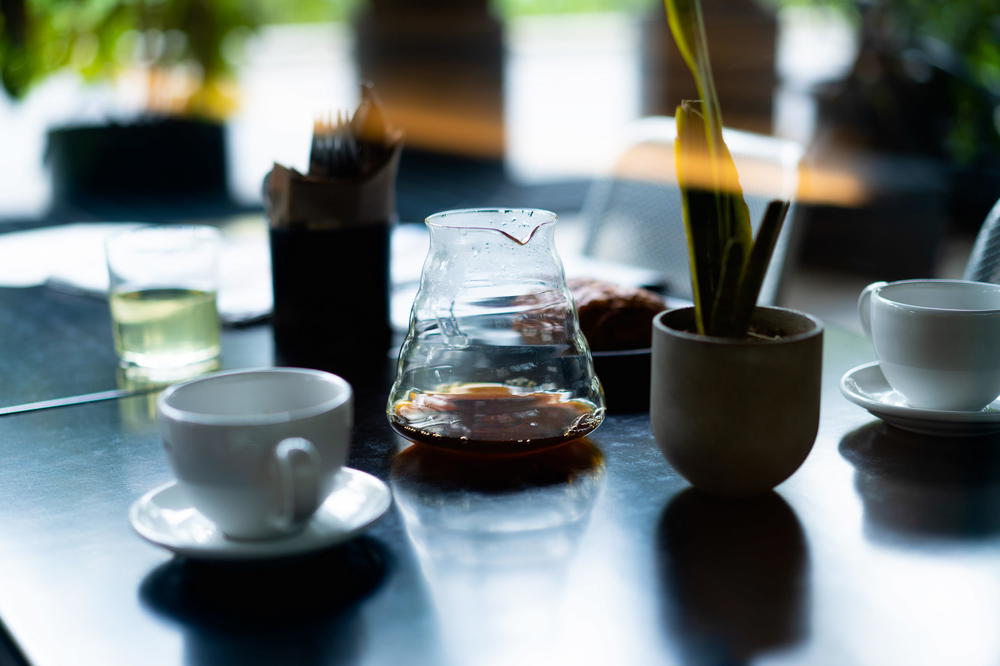 A table in Cafe Buna with coffee cups and a pitcher on it in Mexico City.