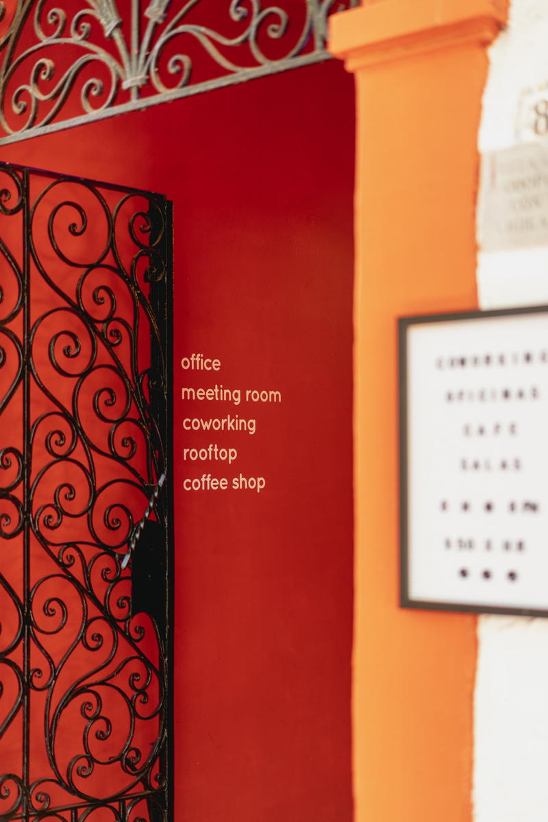 a red wall with a sign that says coffee