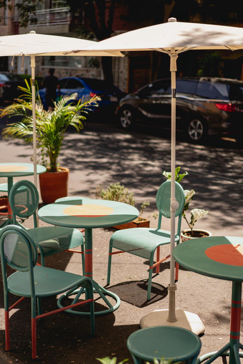 a group of tables and chairs under an umbrella