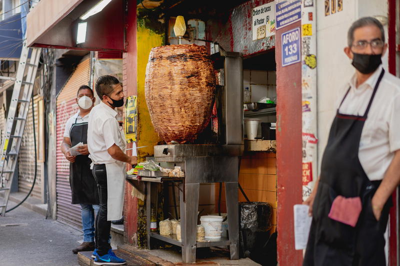 a man standing in front of a food stand
