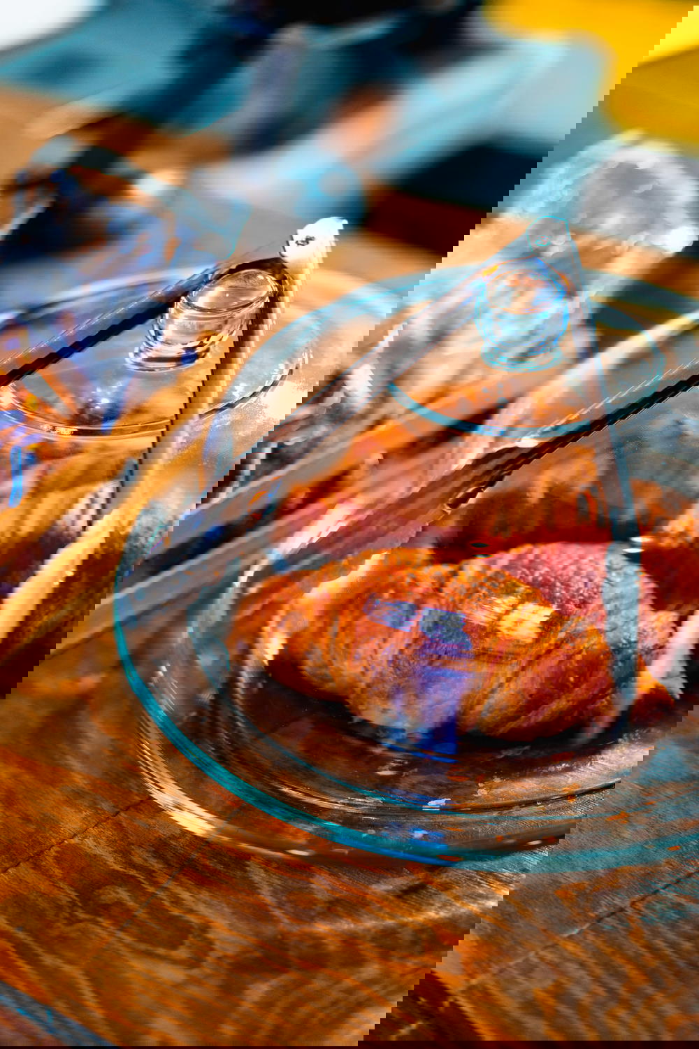 A plate of croissants paired with drip coffee on a wooden table in Mexico.