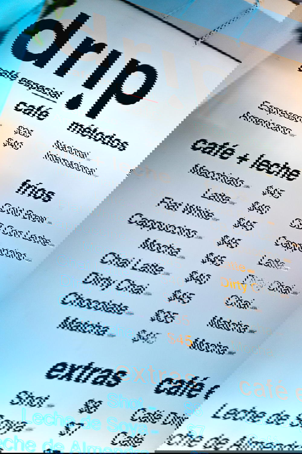 A Mexico City coffee shop menu featuring drip coffee is displayed on a wall.