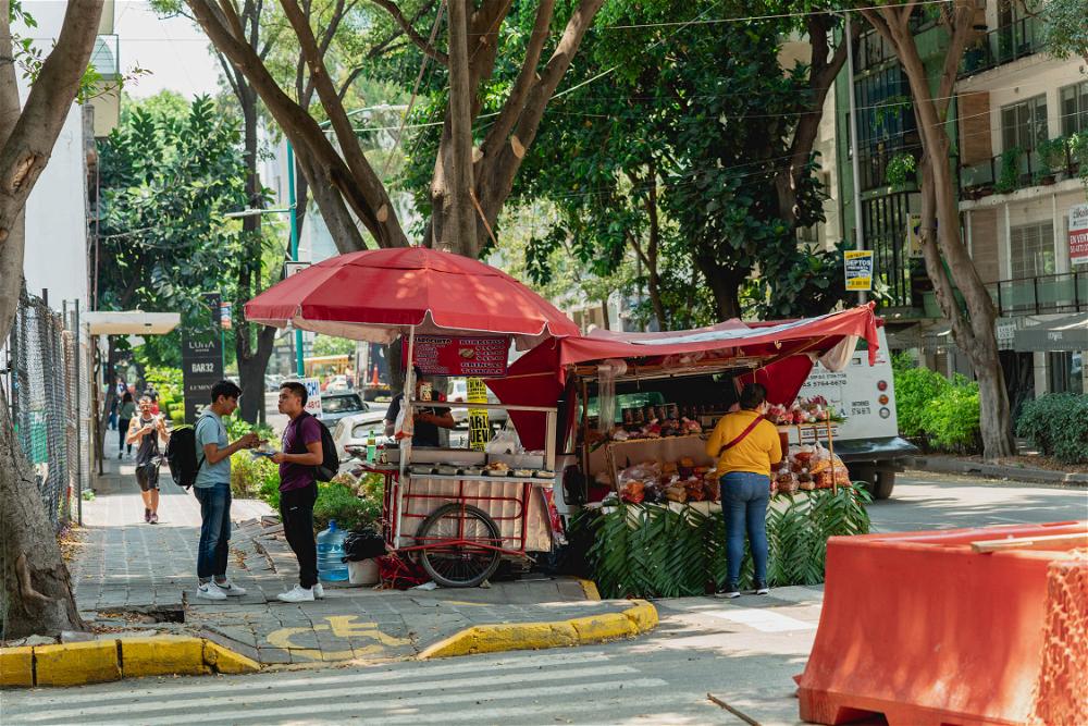 A Mexico City street vendor selling fruit and vegetables on the side of the road.