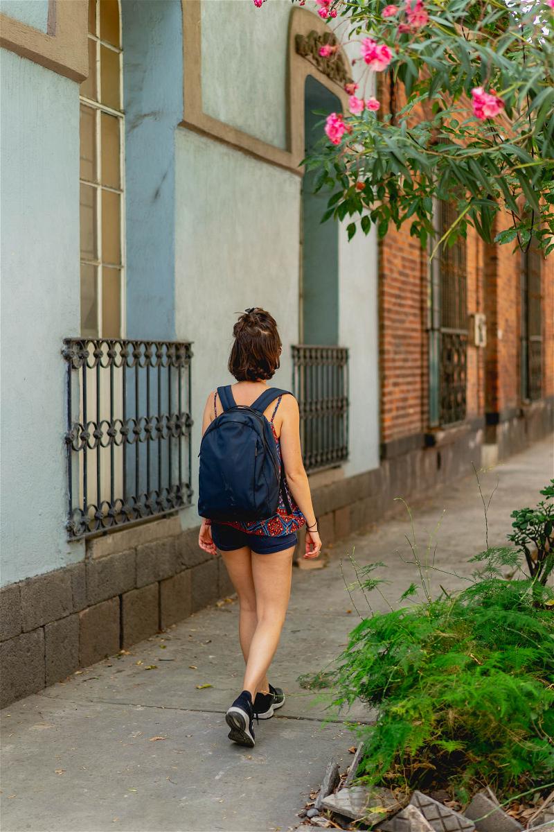 A woman walking down a sidewalk in Mexico City.