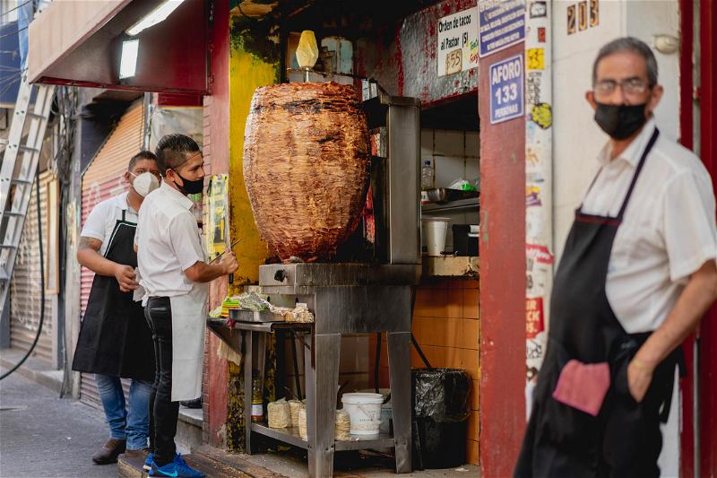 A group of men standing in front of a tandoor in Mexico City, Mexico.