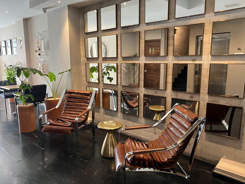 A luxurious lobby in Mexico City adorned with leather chairs and mirrors.