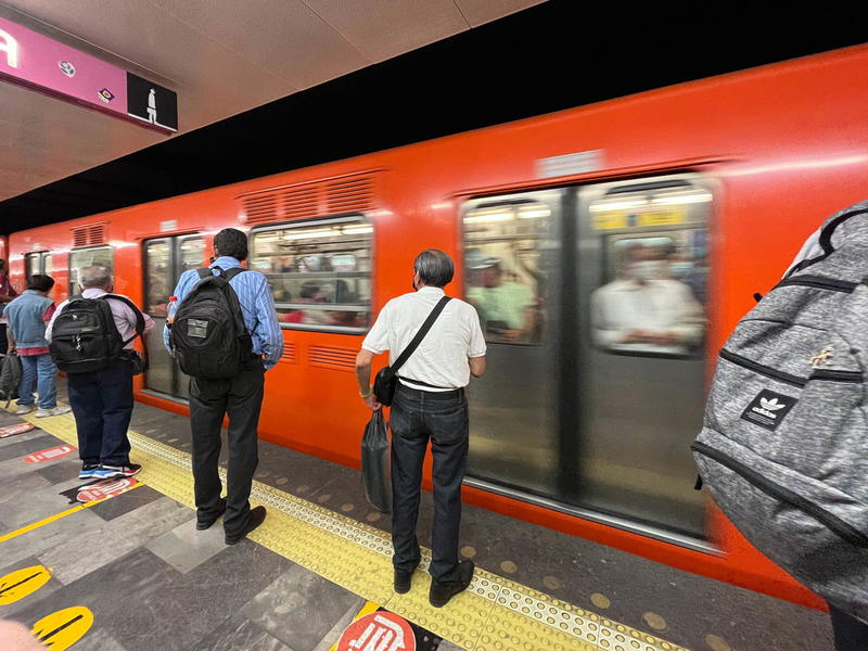 A group of people waiting to board a train in Mexico City.