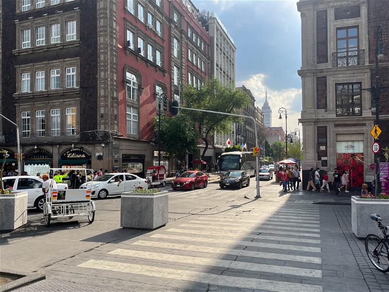 Mexico City street with cars and pedestrians.