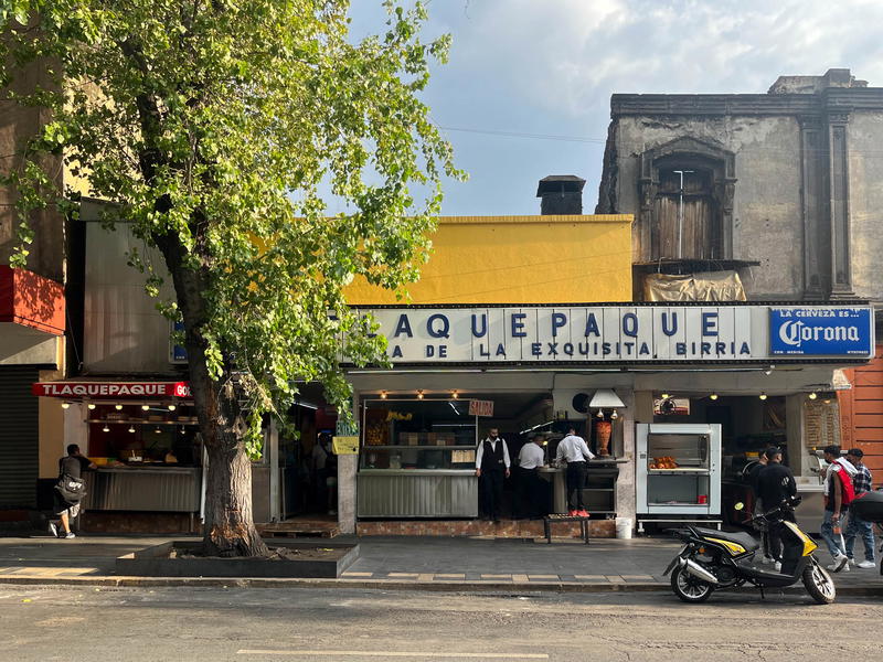 A restaurant and a motorcycle parked on a street in Mexico City, Mexico.