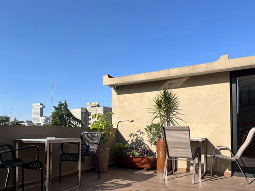 A Mexico City balcony with a table and chairs.