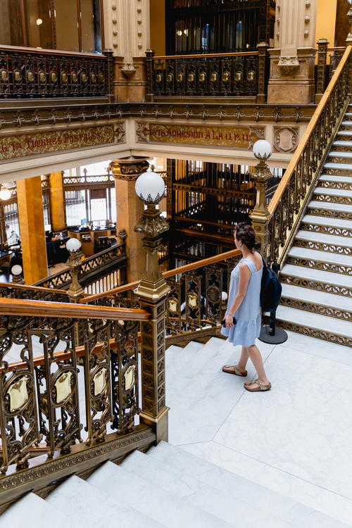 A woman navigating the stairs in a sprawling Mexico City building.