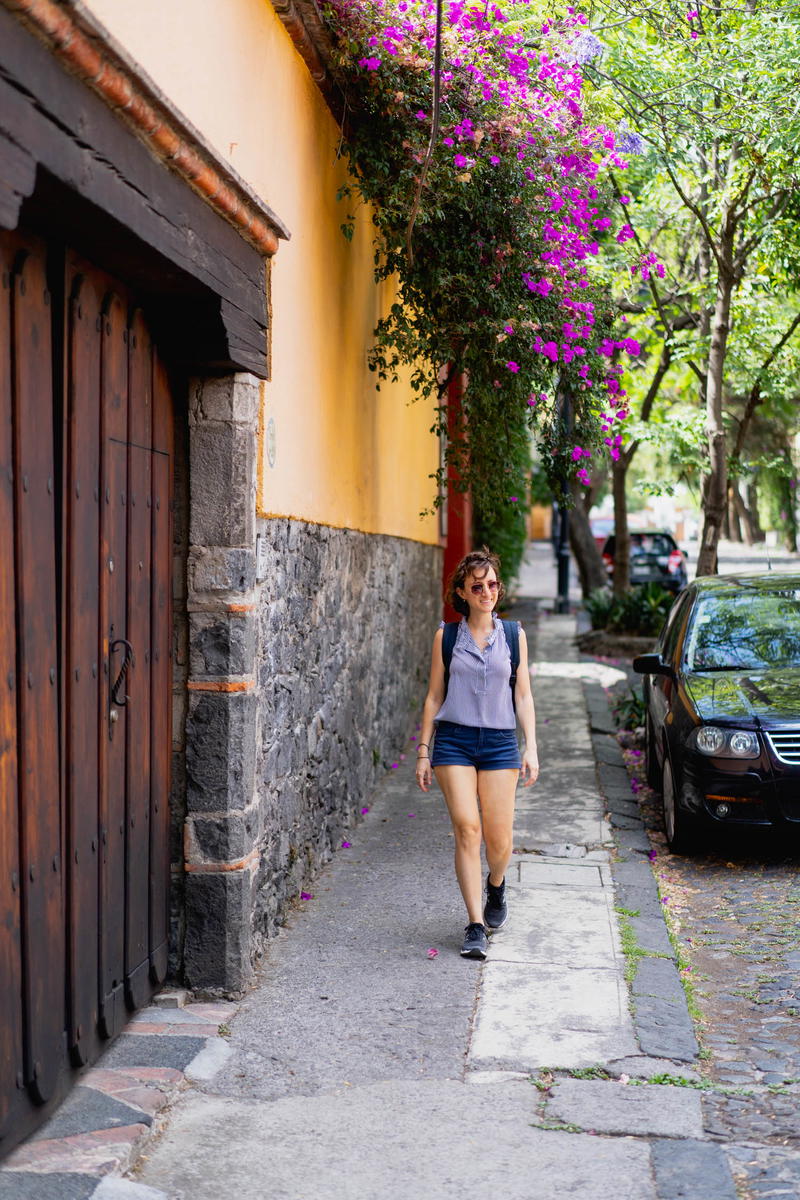 A woman strolling down a cobblestone street in Mexico City, Mexico.