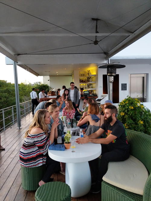 A group of people sitting at tables on a deck in Mexico City.