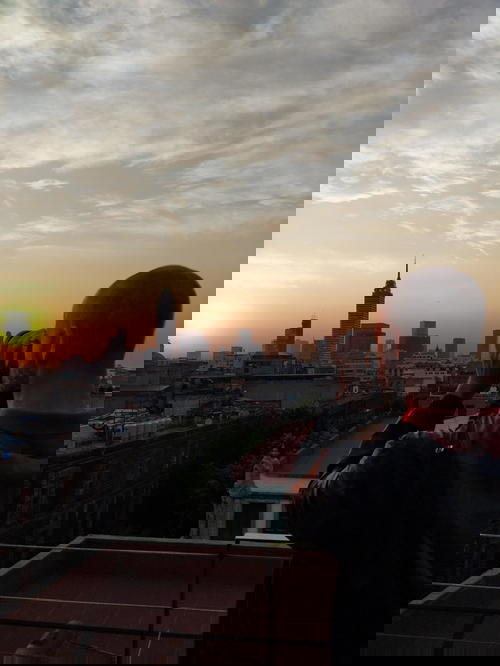 Man taking photo of Mexico City skyline at sunset from La Terraza Catedral Rooftop bar