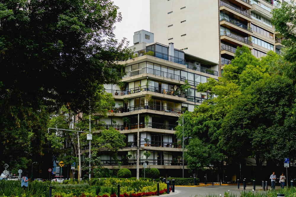 A tall building in the middle of a park in Mexico City.