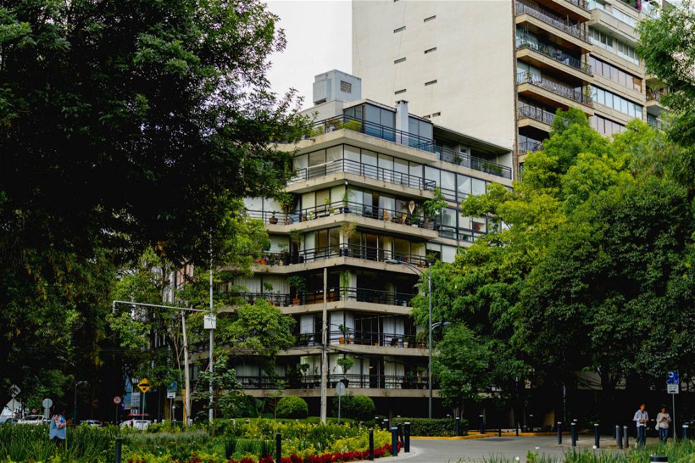 A tall building in the middle of a park in Mexico City.